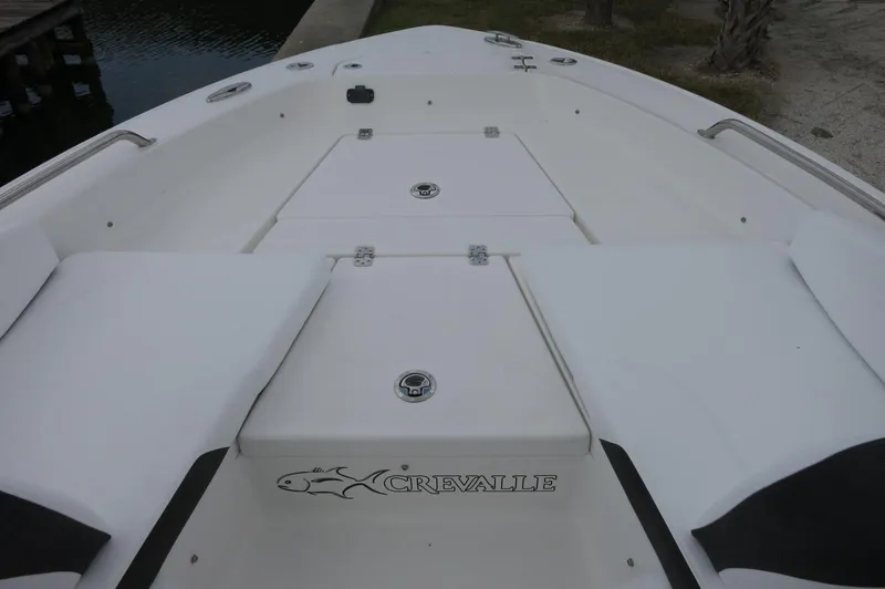 Slide: The Image of 2024 Crevalle 26 HCO boat deck with storage compartments and logo. - 12