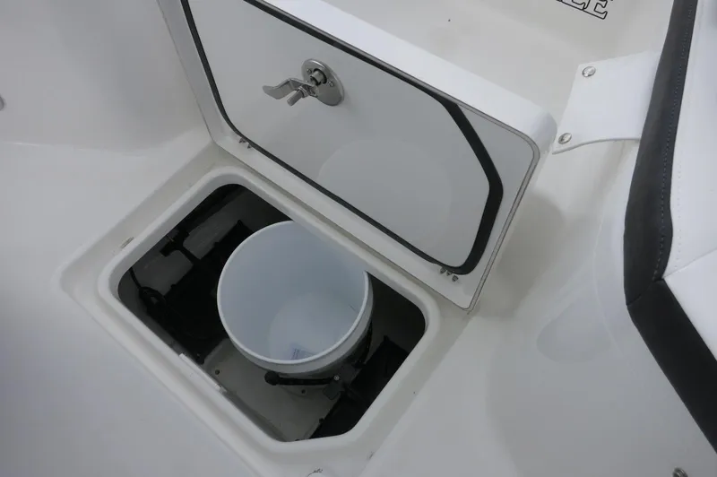 Slide: The Image of 2024 Crevalle 26 HCO boat storage compartment with bucket, featuring secure latch. - 16