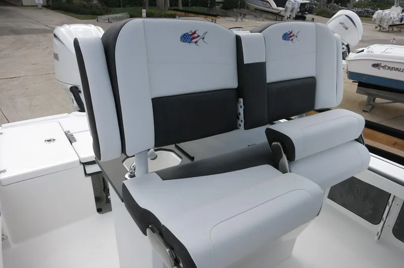 Slide: The Image of 2024 Crevalle 26 HCO boat seating with American flag fish logo, white and black upholstery. - 20