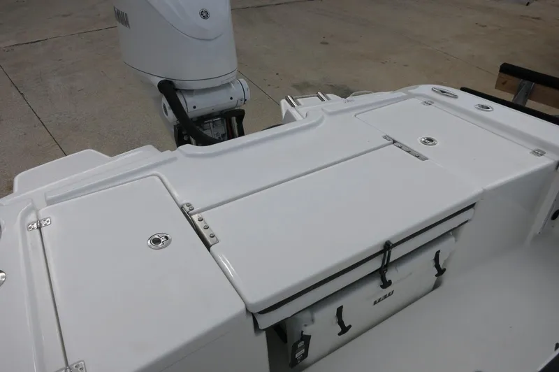 Slide: The Image of 2024 Crevalle 26 HCO boat deck with storage compartments and outboard motor. - 21