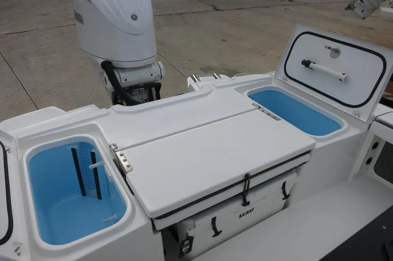 Slide: The Image of 2024 Crevalle 26 HCO boat with open storage compartments and outboard motor. - 23