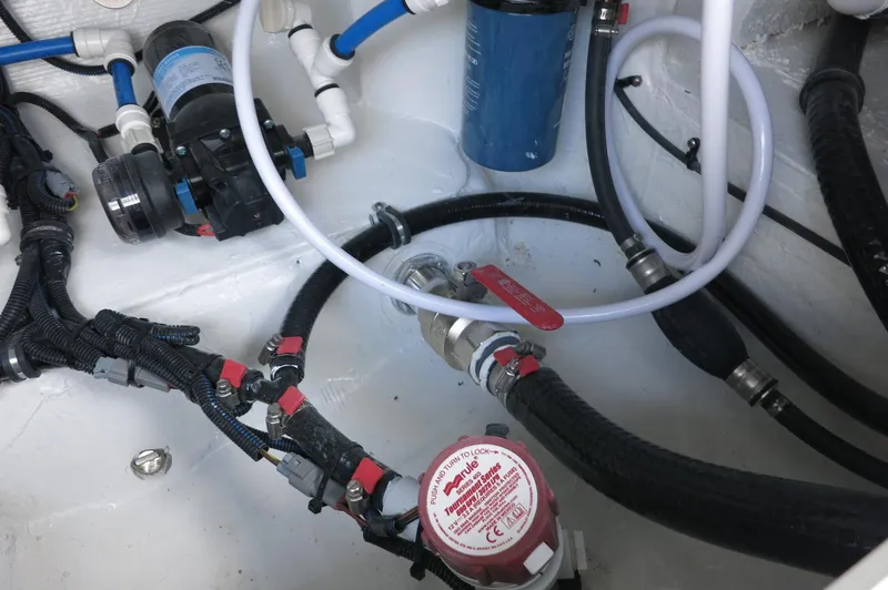 Slide: The Image of 2024 Crevalle 26 HCO boat plumbing system with hoses, valves, and pump components. - 28