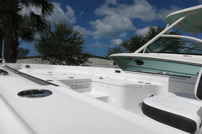 Slide: The Image of 2024 Crevalle 26 HCO boat deck under a clear blue sky with palm trees. - 9