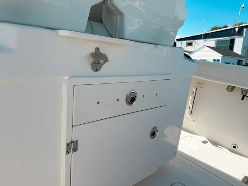Slide: The Image of 2025 Pursuit S 268 Sport boat interior with storage compartment and bottle opener. - 11