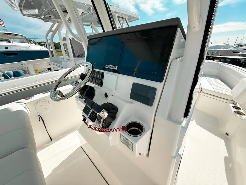 Slide: The Image of 2025 Pursuit S 268 Sport boat cockpit with steering wheel and control panel. - 16