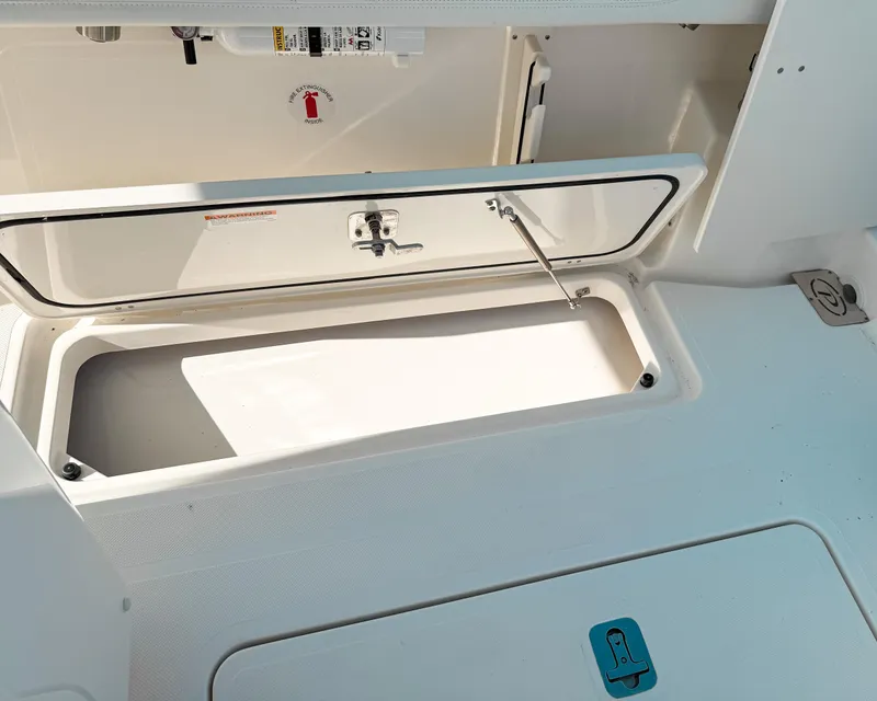 Slide: The Image of 2025 Pursuit S 268 Sport boat storage compartment, open lid, white interior. - 24