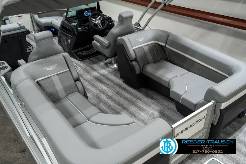 Slide: The Image of 2025 Bennington 22 MFB pontoon boat interior with plush gray seating and modern dashboard. - 12