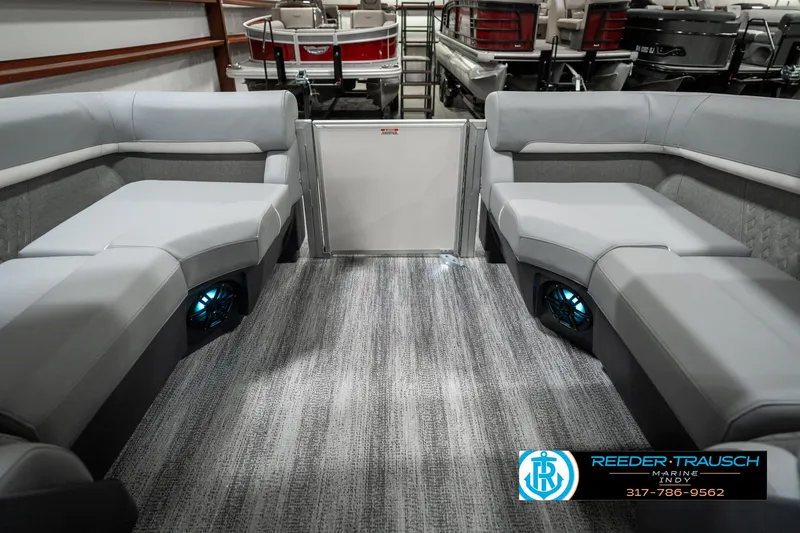 Slide: The Image of 2025 Bennington 22 MFB boat interior with gray seating and blue-lit speakers. - 24