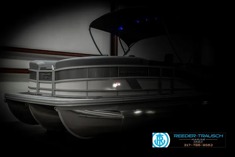 Slide: The Image of 2025 Bennington 22 MFB pontoon boat in a dimly lit showroom. - 4