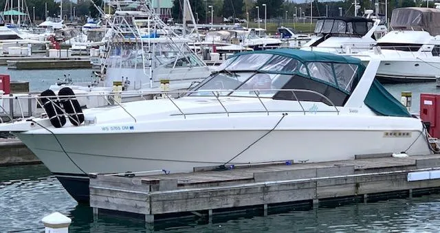 Slide: The Image of 1994 Silverton 34 Express yacht docked in a marina, surrounded by other boats. - 0