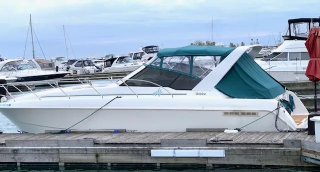 Slide: The Image of 1994 Silverton 34 Express boat docked at a marina with other vessels. - 1