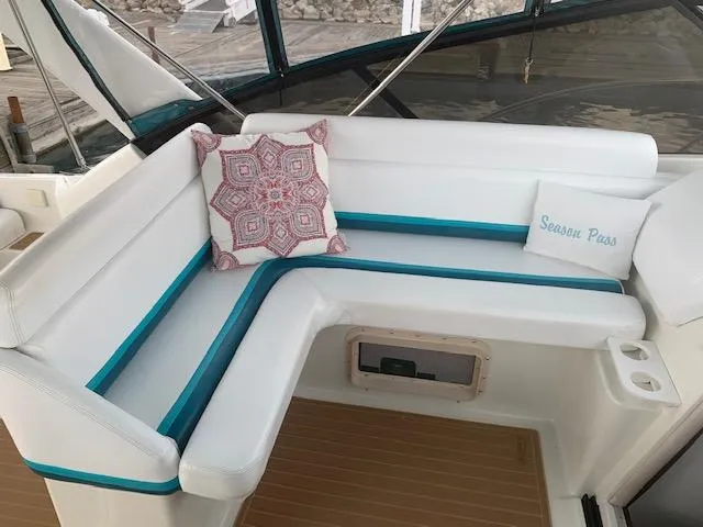 Slide: The Image of 1994 Silverton 34 Express boat interior with white seating and decorative pillows. - 10