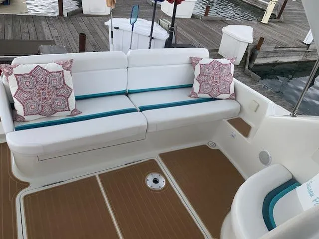 Slide: The Image of 1994 Silverton 34 Express boat interior with white seating and decorative pillows. - 11