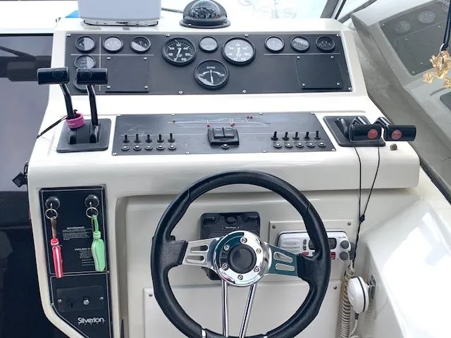 Slide: The Image of 1994 Silverton 34 Express boat dashboard with steering wheel and control panel. - 12