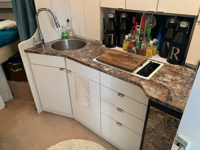 Slide: The Image of 1994 Silverton 34 Express boat kitchen with sink, countertop, and storage cabinets. - 17