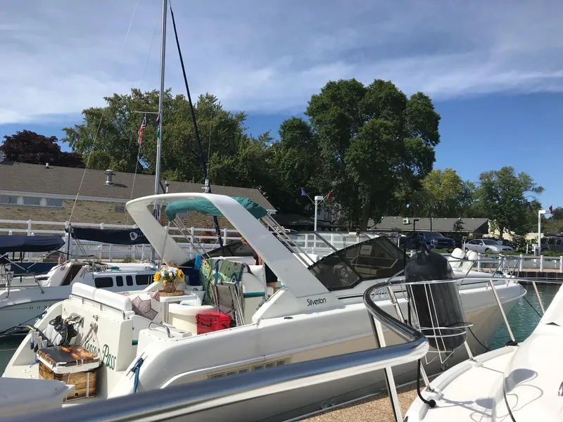 Slide: The Image of 1994 Silverton 34 Express yacht docked at a marina under a clear blue sky. - 2