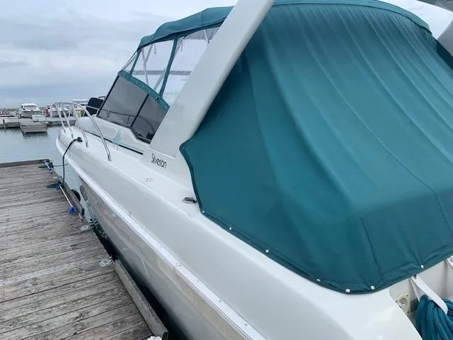 Slide: The Image of 1994 Silverton 34 Express boat docked with teal canopy, side view. - 5