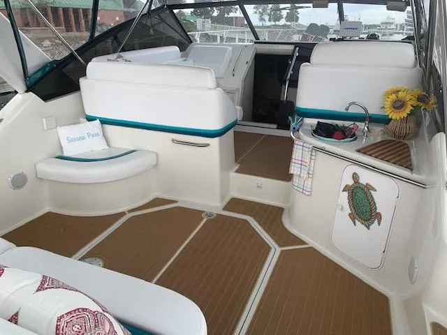 Slide: The Image of 1994 Silverton 34 Express boat interior with white seating, turtle decor, and sunflowers. - 7