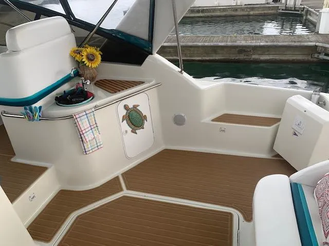 Slide: The Image of 1994 Silverton 34 Express boat interior with turtle decor and sunflowers, docked by the water. - 8