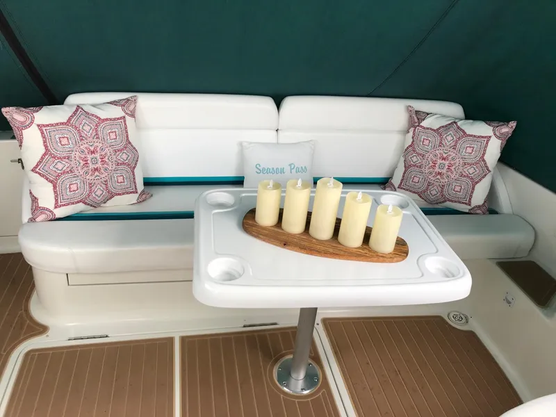 Slide: The Image of 1994 Silverton 34 Express interior with white seating, decorative pillows, and a table with candles. - 9