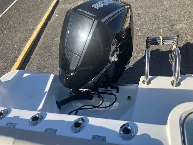 Slide: The Image of 2021 Wellcraft 222 Fisherman boat with Mercury outboard motor, docked on a sunny day. - 13