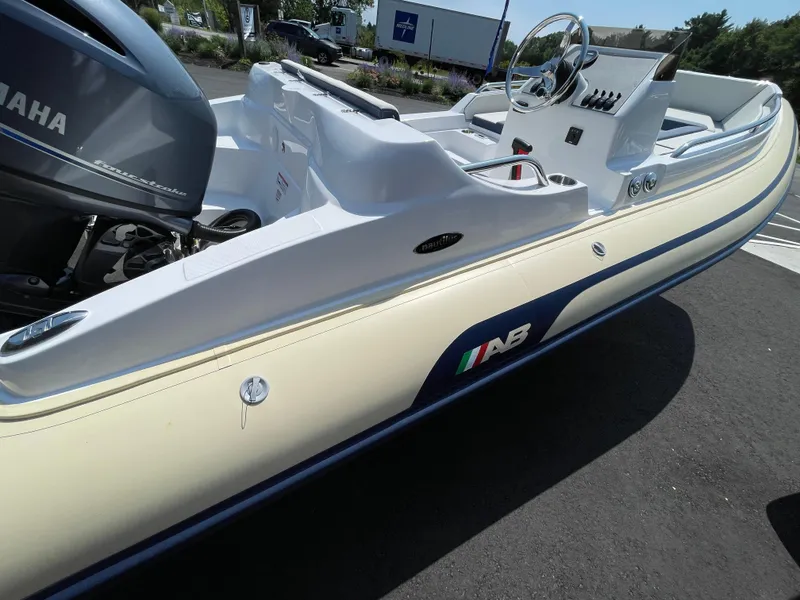 Slide: The Image of 2025 AB Inflatables Nautilus 17 DLX boat with Yamaha engine, parked on asphalt. - 17