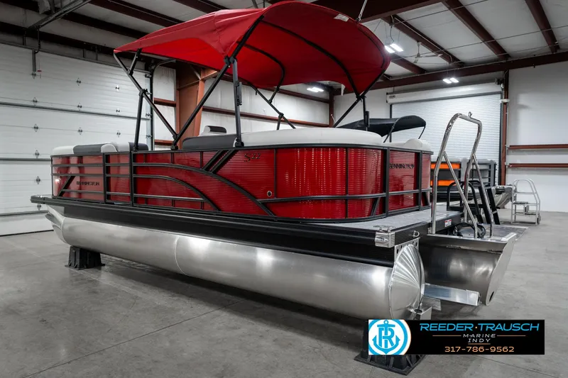 Slide: The Image of 2025 Bennington 22 SSR pontoon boat with red canopy in a showroom. - 10