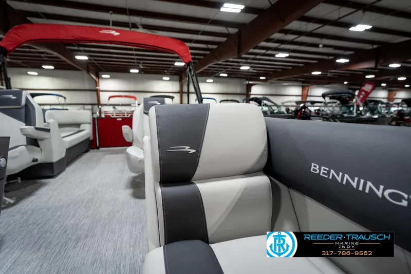 Slide: The Image of 2025 Bennington 22 SSR pontoon boat interior with gray and black seating in a showroom. - 24
