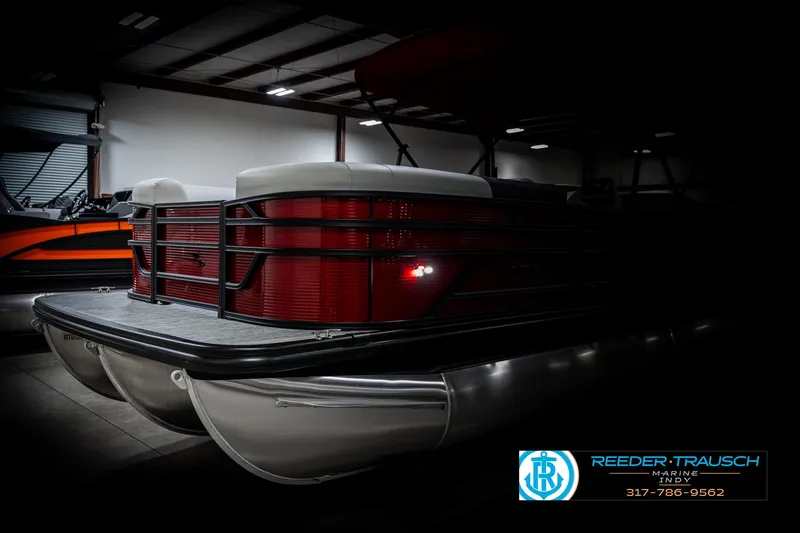 Slide: The Image of 2025 Bennington 22 SSR pontoon boat in a dimly lit showroom. - 4