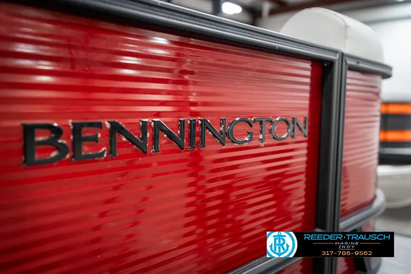 Slide: The Image of 2025 Bennington 22 SSR boat with red exterior and logo, showcased indoors. - 48