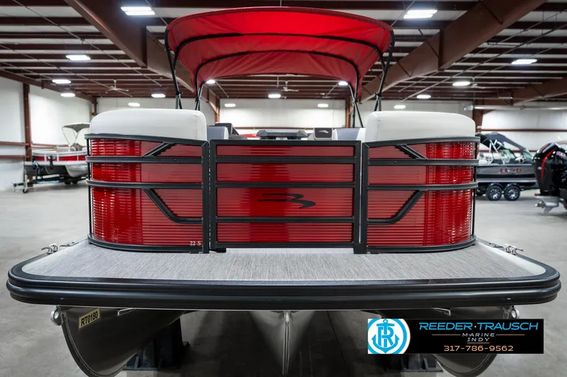 Slide: The Image of 2025 Bennington 22 SSR pontoon boat with red exterior in a showroom. - 5