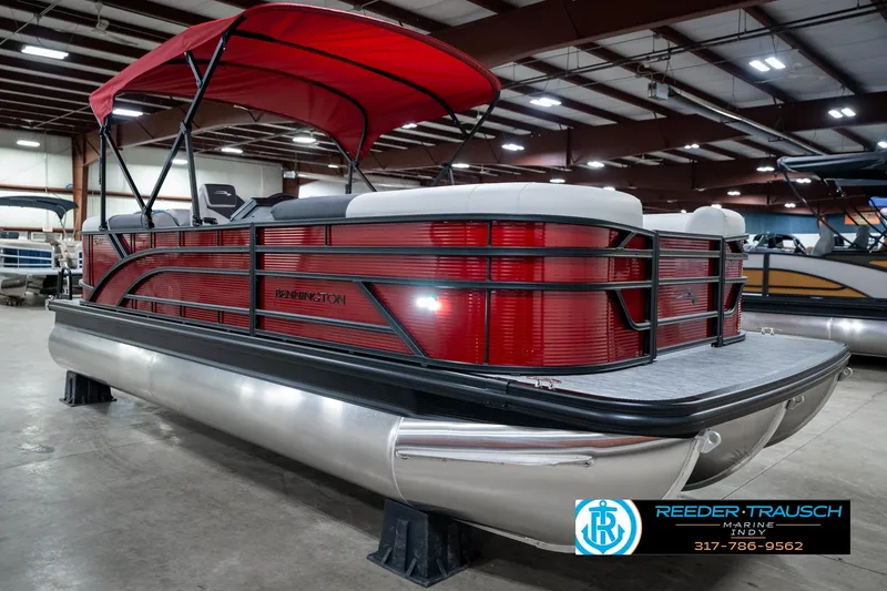Slide: The Image of 2025 Bennington 22 SSR pontoon boat with red exterior and canopy in showroom. - 6