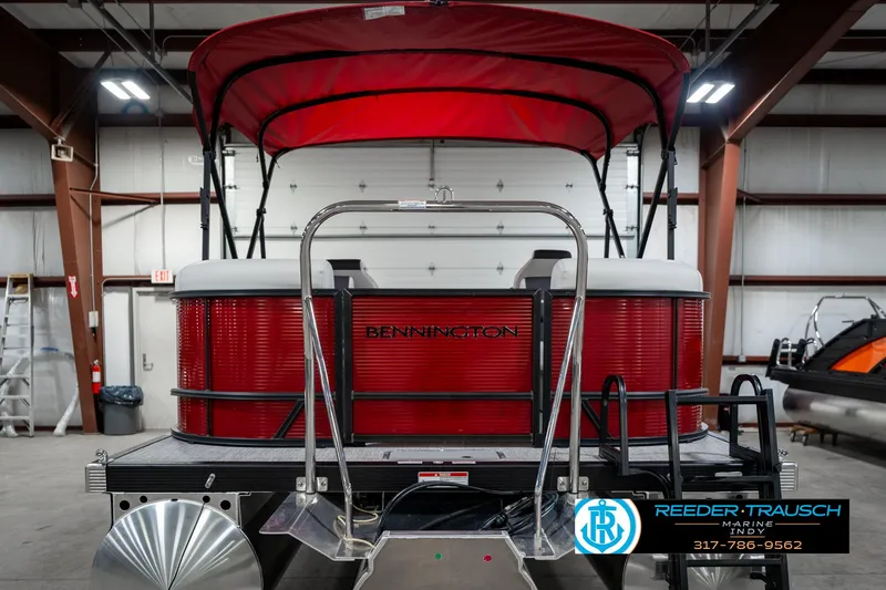 Slide: The Image of 2025 Bennington 22 SSR pontoon boat with red canopy in a warehouse setting. - 9