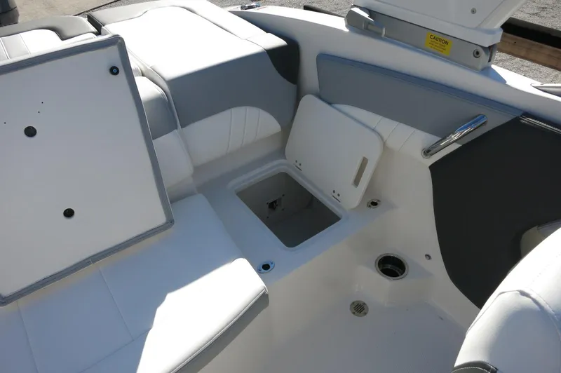 Slide: The Image of 2025 Chaparral 21 SSi Outboard boat interior with open storage compartments and seating. - 23