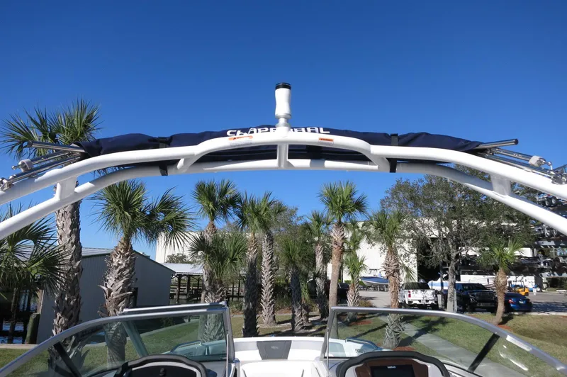 Slide: The Image of 2025 Chaparral 21 SSi Outboard boat with wakeboard tower, palm trees in background. - 42