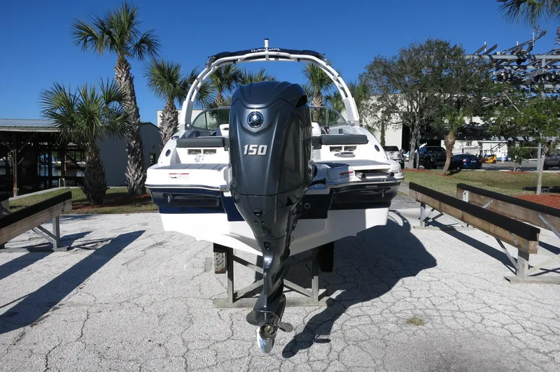 Slide: The Image of 2025 Chaparral 21 SSi Outboard boat with 150 HP engine, parked outdoors. - 6
