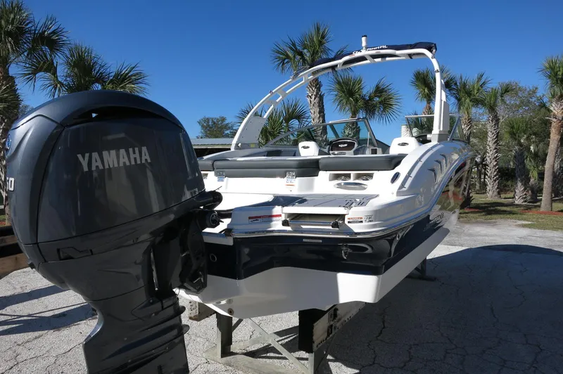 Slide: The Image of 2025 Chaparral 21 SSi Outboard boat with Yamaha engine, parked outdoors under clear blue sky. - 7