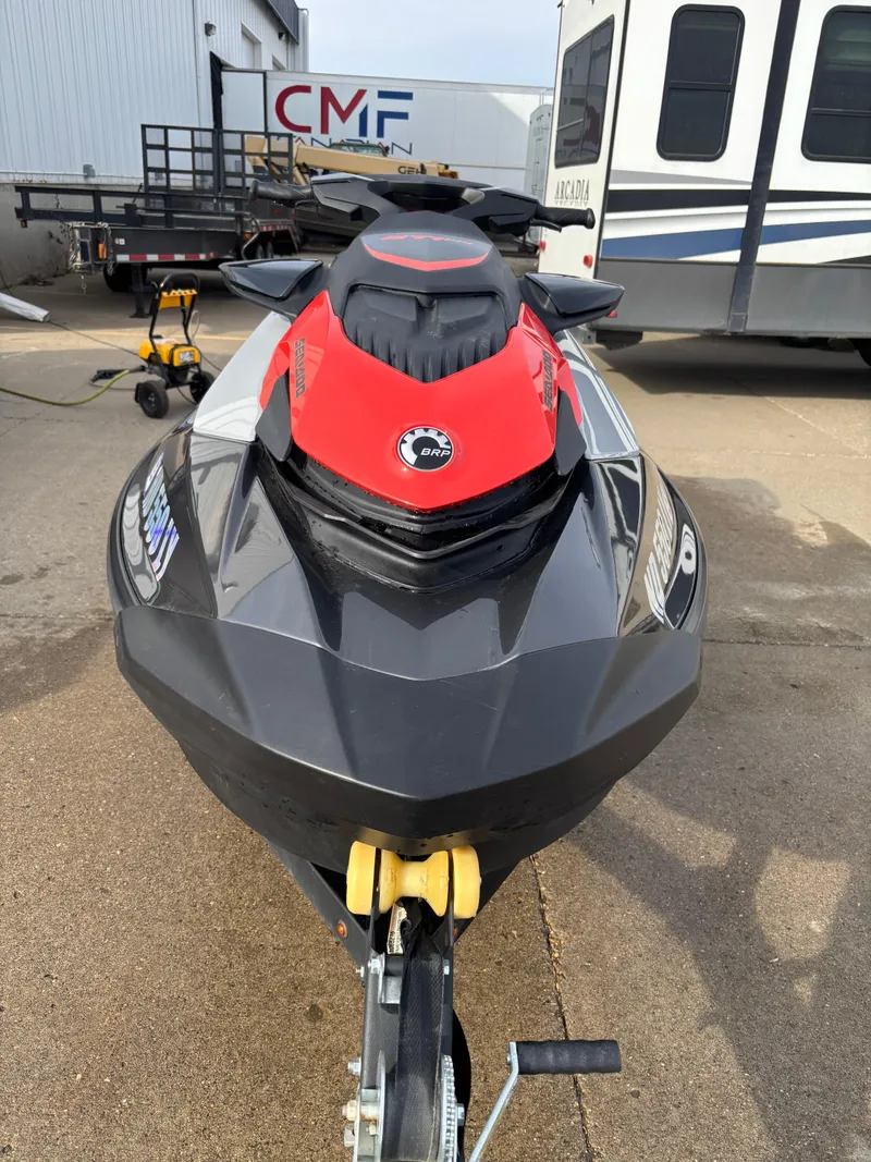 Slide: The Image of 2023 Sea-Doo GTI SE 170 jet ski, black and red, parked on trailer. - 1