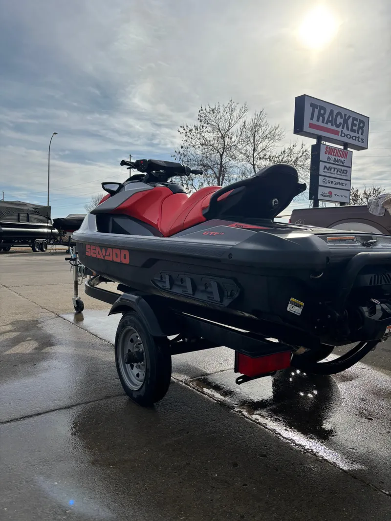 Slide: The Image of 2023 Sea-Doo GTI SE 170 jet ski on trailer, parked outdoors near dealership. - 3