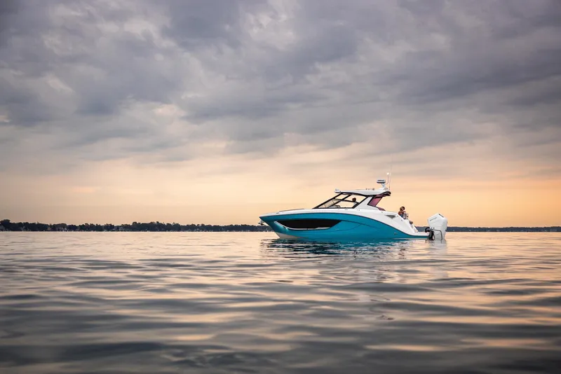 Slide: The Image of Open storage compartment on 2026 Hurricane SunDeck 3200 OB boat with hand reaching inside. - 17