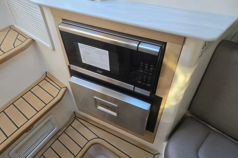 Slide: The Image of 2026 Hurricane SunDeck 3200 OB interior with built-in microwave and steps. - 53