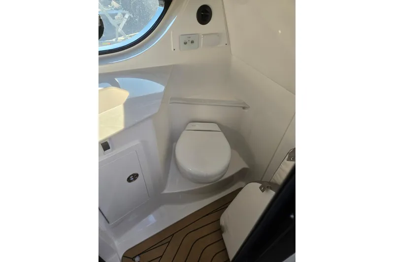 Slide: The Image of 2026 Hurricane SunDeck 3200 OB boat interior with modern toilet and sleek design. - 56