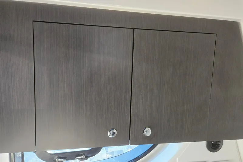 Slide: The Image of 2026 Hurricane SunDeck 3200 OB interior cabinet with sleek wood finish. - 60