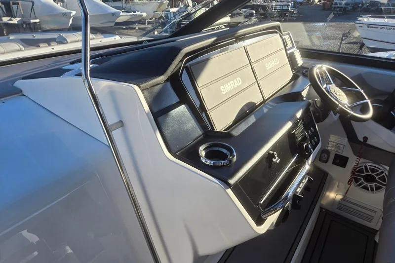 Slide: The Image of 2026 Hurricane SunDeck 3200 OB boat dashboard with Simrad displays and steering wheel. - 66