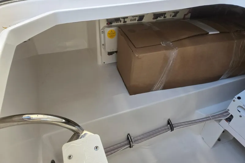 Slide: The Image of 2026 Hurricane SunDeck 3200 OB storage compartment with cardboard box inside. - 72