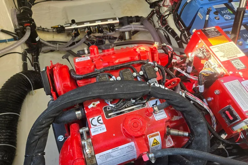 Slide: The Image of Engine compartment of a 2026 Hurricane SunDeck 3200 OB, featuring red and black components. - 76