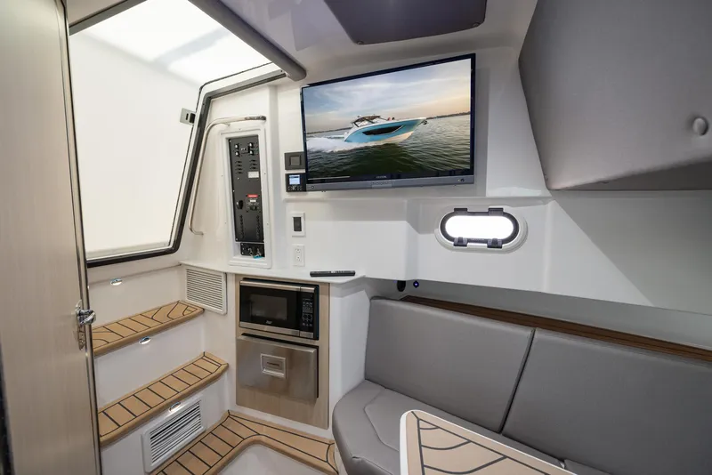 Slide: The Image of 2026 Hurricane SunDeck 3200 OB boat on trailer, surrounded by other boats, under clear blue sky. - 8