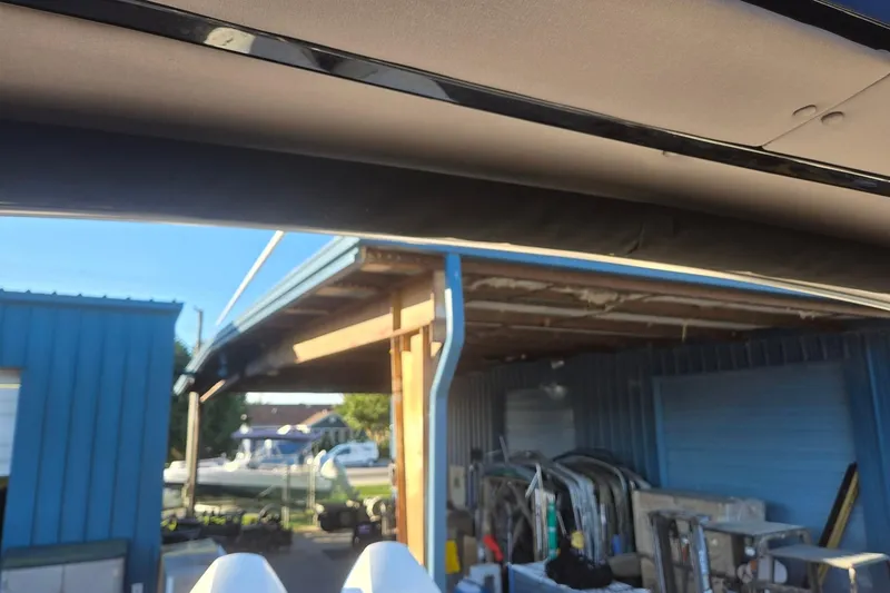 Slide: The Image of Outdoor view of a 2026 Hurricane SunDeck 3200 OB near a blue storage building. - 81