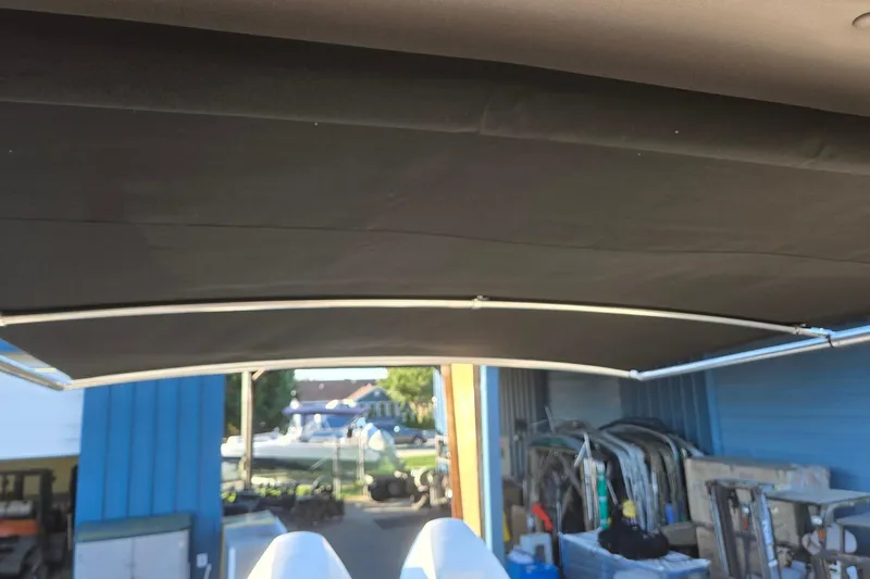 Slide: The Image of 2026 Hurricane SunDeck 3200 OB boat canopy in a storage area. - 82