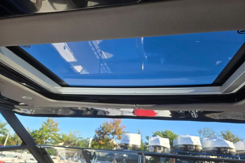 Slide: The Image of 2026 Hurricane SunDeck 3200 OB boat with open sunroof, showcasing clear blue sky. - 83